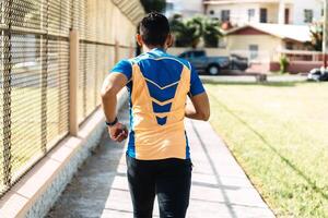 Back view of a young man running photo