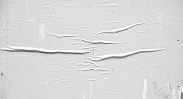 A white wall with peeling paint and a crack photo