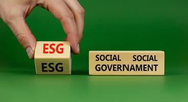 Social, economic, and governance concept with hand holding block with esg and social government photo