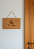 A rustic wooden sign hangs on a wall displaying the word Mockup and a nature inspired design psd