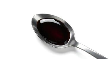A spoon with a black liquid in it photo