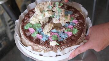 stick spoon into cake take large piece of cake from middle eat awkwardly sloppy cake with cream cake with pink frosting and green leaves on top. The cake is decorated with pink roses. Rotating dessert video