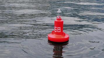 A bright red buoy marked with the number 68 floats serenely on the calm water, guiding vessels safely video
