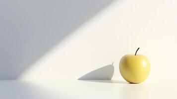 A yellow apple sits on a white countertop, casting a shadow on the wall photo