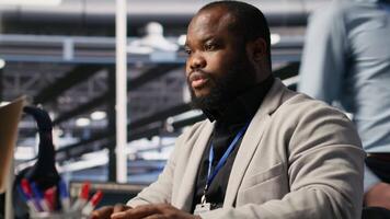 Data center computer scientist monitoring servers performing AI training and inference tasks. African american server hub worker overseeing computing systems managing deep learning storage, camera A video