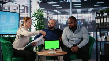 Multicultural professionals networking next to green screen in an office, combining leadership, opportunity and vision to develop career success story and company growth. Camera A. video