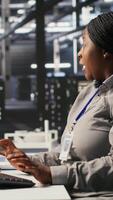 Vertical Panicked system administrator in data center reacting to spyware warning on PC screen, launching emergency response protocol. Worker trying to repair hacked equipment systems, camera A video