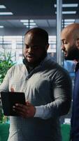 Vertical Diverse group of CEOs applying data analysis and strategic thinking to guide partnership decisions, using research and performance metrics. Multicultural perspectives in office lobby. Camera B. video