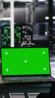 Vertical Chroma key laptop and desktop PC used for visualizing AI workloads and inspecting server room layout. Green screen notebook supporting artificial intelligence systems through simulated computing tasks video
