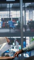 Vertical Diverse group of business professionals collaborating in an office, leveraging performance analysis, negotiation and shared expertise to achieve global growth and investment results. Camera B. video