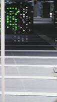 Vertical Close up of data center PCs showing deep learning visualization debugging tools. Computer systems in server hub powering artificial intelligence and automated research tasks, handheld camera shot video