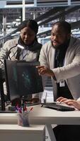 Vertical Engineering team in data center using AI automation during maintenance session. Server hub coworkers doing brainstorming, configuring deep learning models in hardware rigs, camera A video