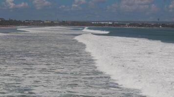 Aerial view of ocean waves with surfers near the shore in Lombok video
