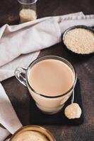 Coffee with sesame paste tahini in a cup on the table vertical view photo