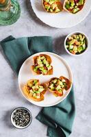 Mini baked pita cups with guacamole on a plate on a table top and vertical view photo