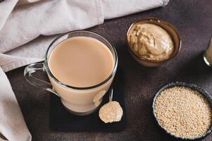 Coffee with sesame paste tahini in a cup on the table photo