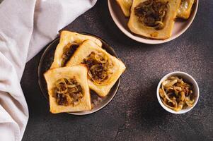 Upside down tarts with caramelized onions on a plate on a table top view photo