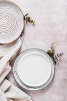 Diet and fasting concept, empty plates, napkins and twigs on gray background top and vertical view photo