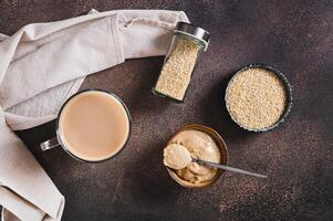 Tahini latte with sesame spread in a cup on the table top view photo