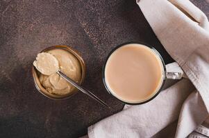 Close up of tahini latte with sesame spread in a cup on the table top view photo