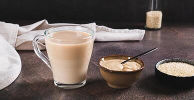 Tahini latte with sesame spread in a cup on the table web banner photo