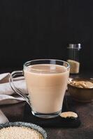 Tahini latte with sesame spread in a cup on the table vertical view photo