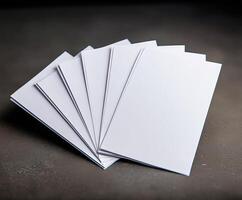 Blank white envelopes fanned on dark surface. photo
