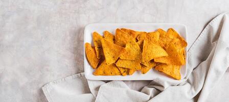 Crispy nachos in spices on a plate on the table top view web banner photo