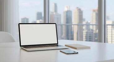 Laptop and Smartphone on Desk with City View photo