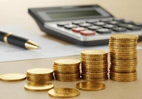 Coin Stacks Near Calculator and Pen photo