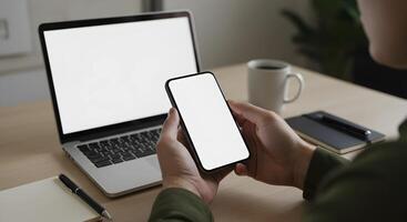 Person Holding Phone Next to Laptop and Coffee photo