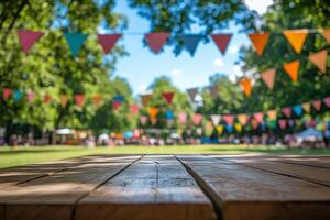 Empty wooden table in colorful outdoor festival setting with bunting and flags, sunny backdrop for summer celebrations and product placement. Festive concept photo