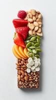 Vertical image of energy bar featuring almonds, white chocolate, and fresh fruits like on white background. Food photography concept photo