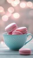 Pink macarons in charming teal cup, set against a soft bokeh background, creating a sweet and delightful treat presentation. Dessert concept photo