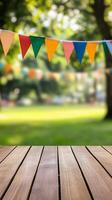 Colorful bunting strung above wooden table set for a summer picnic celebration. Outdoor event concept photo