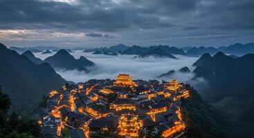 Ancient Chinese village at dusk nestled in misty mountains landscape photo