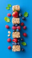 Vertical image of colorful stack of granola bars with fresh berries and mint leaves. Food concept photo