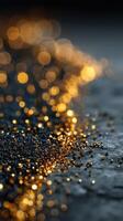 Glistening golden particles spread across a textured dark surface during twilight hours photo