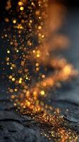 Sparkling golden particles create a mesmerizing cascade on a dark surface during evening light photo