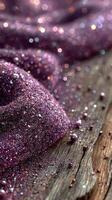 Sparkling purple glitter scattered on weathered wooden surface creating a shimmering effect photo