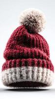 Cozy knit hat with pom pom in red and white displayed on a light background photo