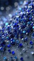 Blue gemstones scattered on a surface with sparkling reflection in a creative abstract design photo