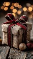 Rustic gift wrapped in burlap with festive ribbon and decorative ornaments during the holiday season photo