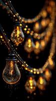 Warm glowing light bulbs hang on strings creating a cozy atmosphere during a rainy evening in a garden photo