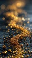 Golden glitter particles create a shimmering river effect on a dark surface in evening light photo