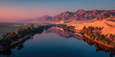 Desert landscape at dusk with a tranquil river reflecting the mountains and sky photo