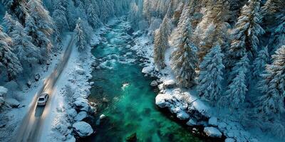 Scenic winter drive along a river surrounded by snow-covered trees in a tranquil landscape photo