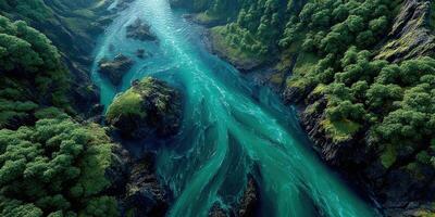 Flowing turquoise river winding through lush forested mountains at dawn photo