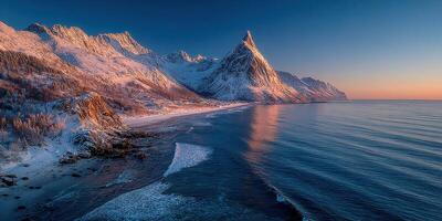 Scenic winter landscape with snow-capped mountains and calm waters during sunset photo