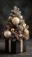 Decorative Christmas tree arrangement in a gift box with golden ornaments and silver accents on a dark background photo